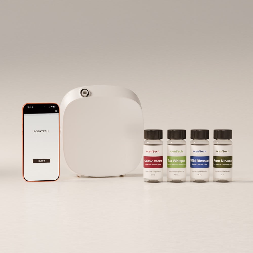 A Scentech electric oil diffuser next to the phone app and three 65 ml fragrance pods